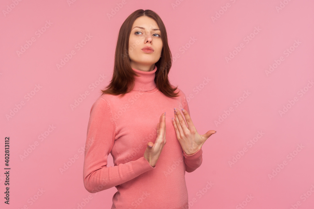 Self confident egoistic brunette woman pointing on herself with arrogance and satisfaction, proud of herself, bragging with achievements. Indoor studio shot isolated on pink background