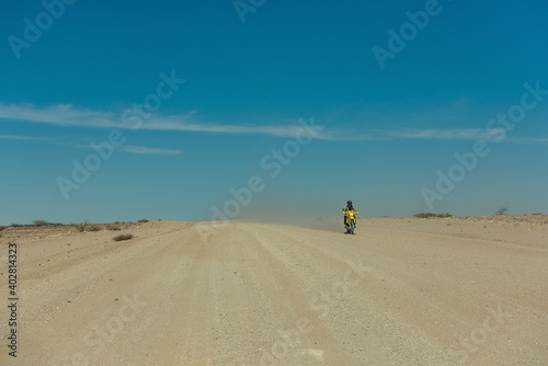 Motorcyclist on a dirty road in the Namib Desert  Namibia