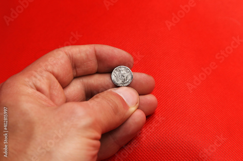 Vintage russian silver coin in hand on red background