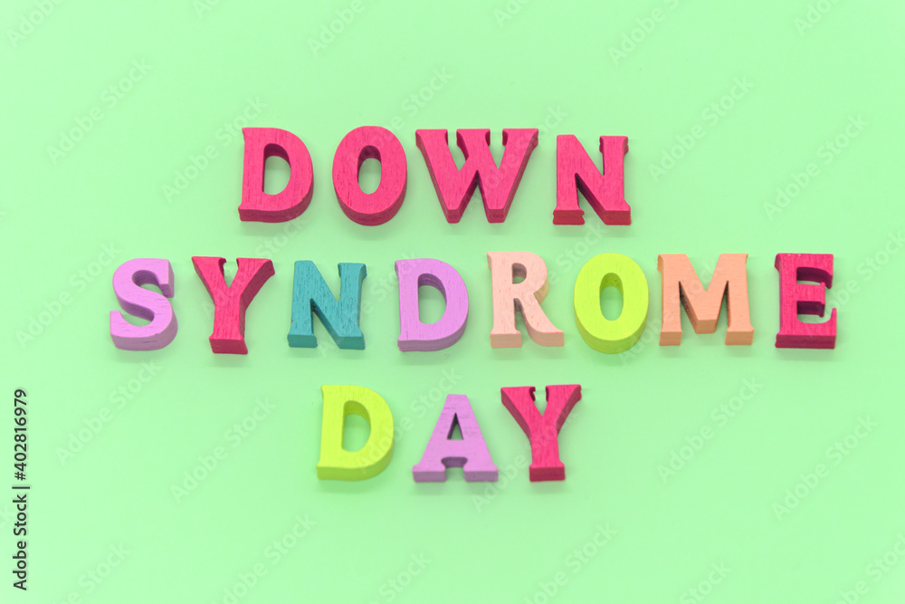 World down syndrome day - inscription laid out of wooden letters on light green background. Down syndrome awareness concept. Banner, illustration, poster. 
