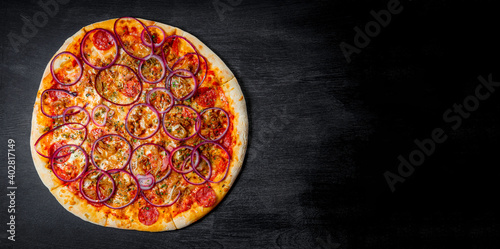  Italian pizza with sausage and onion rings on black background, top view, banner