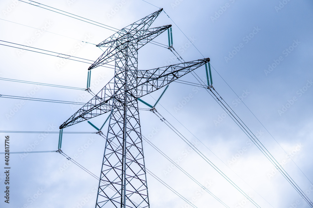 Photo of a high voltage tower in the middle of nature. Photo from the bottom. Electricity, power, light.