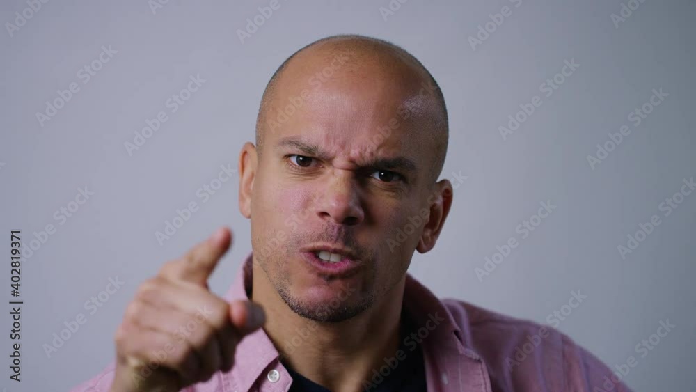 Portrait of angry man pointing to camera and expressing his anger, in slow motion