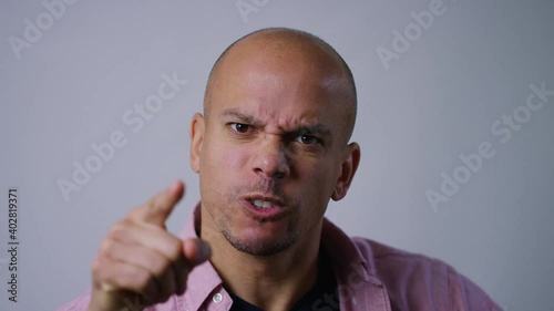 Portrait of angry man pointing to camera and expressing his anger, in slow motion