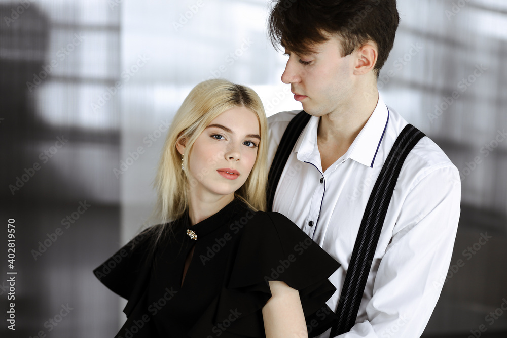 Young couple of businessman and woman are standing in a modern office. Portrait of successful business people Young couple of businessman and woman are standing in a modern office. Portrait of successful business people