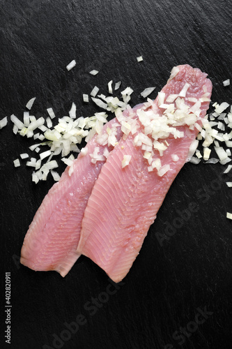 Traditional dutch maties herring with chopped onion on a dark background top view  photo