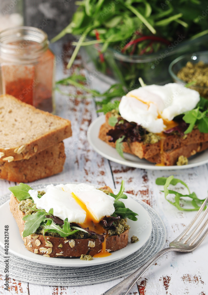 Homemade sandwiches with pesto, green salad and poached eggs Homemade sandwiches with pesto, green salad and poached eggs