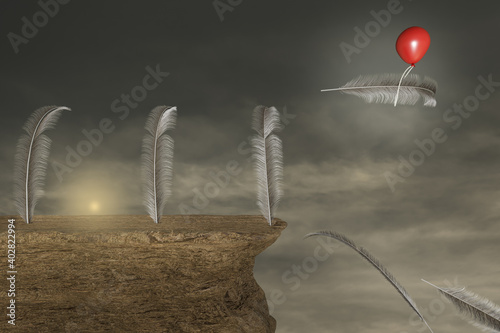 Vászonkép Feather on a stone cliff with a red balloon help to escape one feather from falling in a sunset day