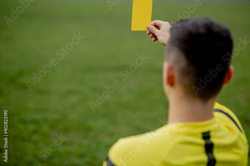 Referee showing a red card to a displeased football or soccer player while gaming. Concept of sport, rules violation, controversial issues, obstacles overcoming.