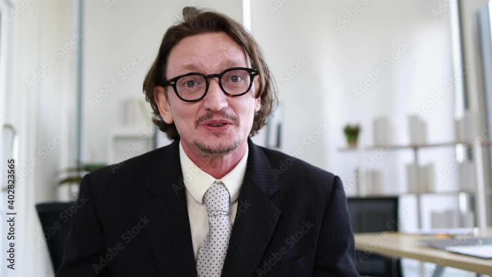 Confident Caucasian businessman in eyeglasses speaking through webcam for vdo conference, Telecommunication online concept Confident Caucasian businessman in eyeglasses speaking through webcam for vdo conference, Telecommunication online concept