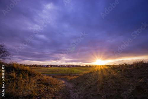 Sonnenstrahlen zwischen zwei Hügel auf einem Feld