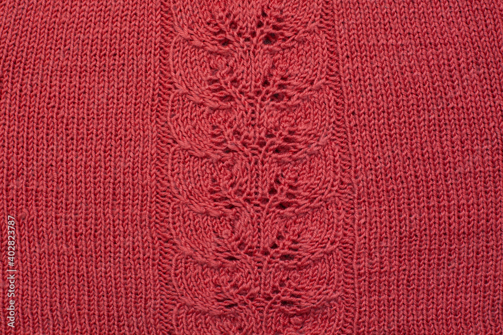 Red knitted cotton fabric, hand knit, plain knitting,  branch in  knitting needles. Horizontal photo