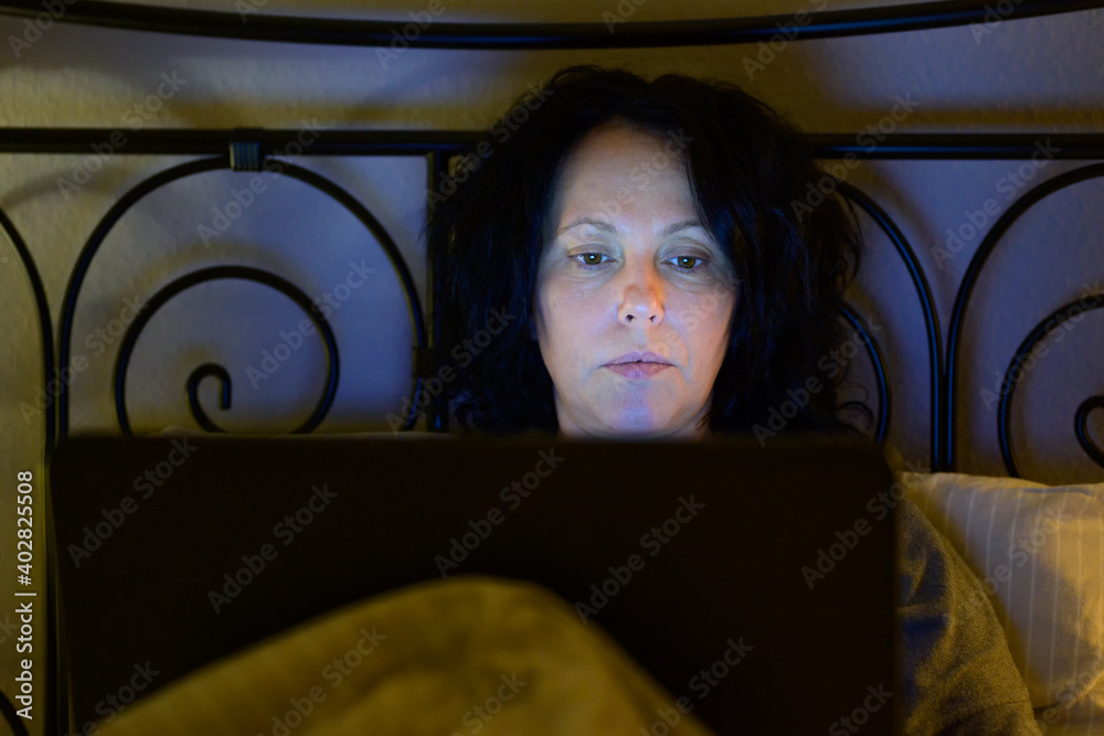 Woman working or watching media at night Woman working or watching media at night
