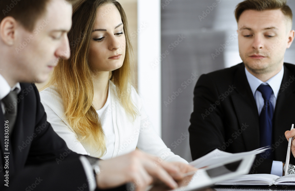 Business people or lawyers discussing questions at meeting in modern office. Unknown businessman and woman with colleague sitting and working at the glass desk. Teamwork and partnership concept Business people or lawyers discussing questions at meeting in modern office. Unknown businessman and woman with colleague sitting and working at the glass desk. Teamwork and partnership concept