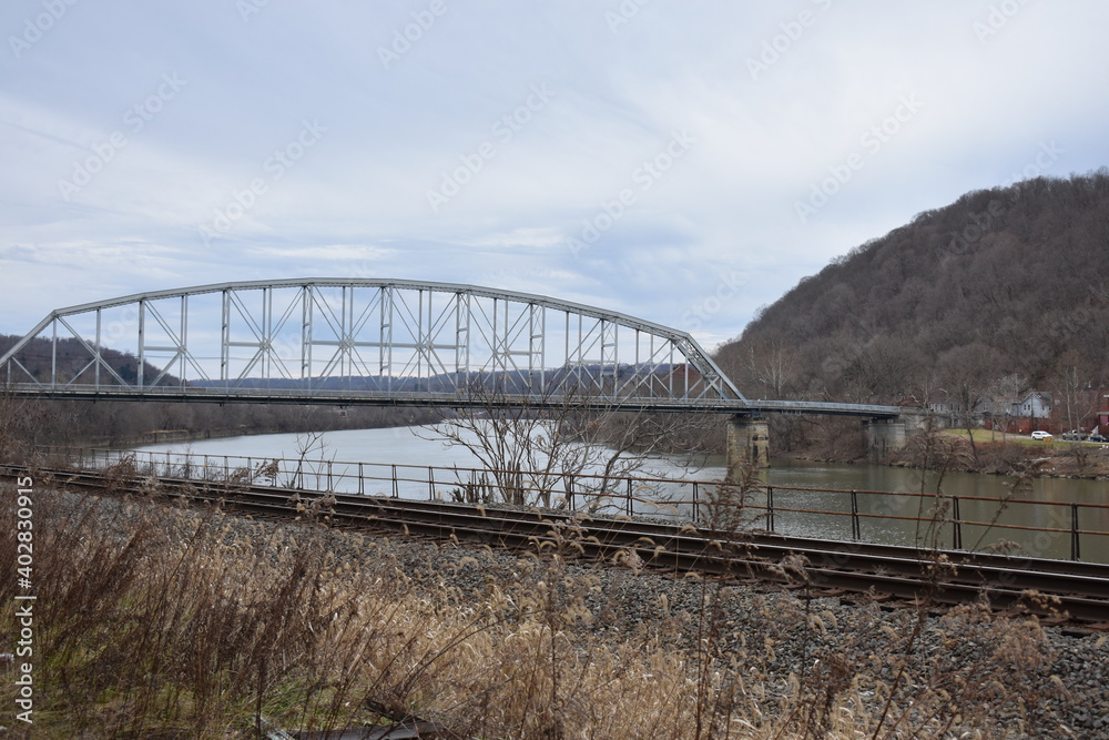 Fototapeta premium Old bridge spanning river with railroad tracks Brownsville Pennsylvania 2019