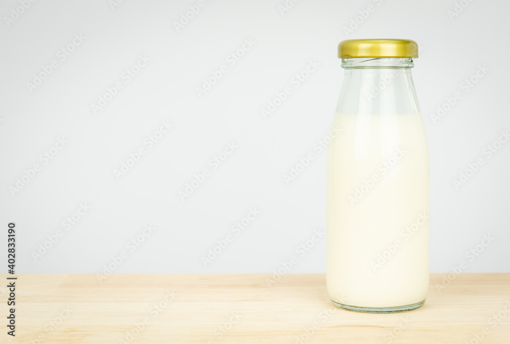 Bottles with fresh milk on a wooden table..Raw milk is high in calcium and protein to drink for all ages..Milk consumption nutritious and healthy dairy products concept. Bottles with fresh milk on a wooden table..Raw milk is high in calcium and protein to drink for all ages..Milk consumption nutritious and healthy dairy products concept.