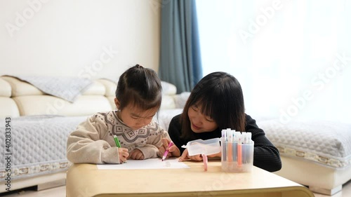 mother and daughter are drawing on a table