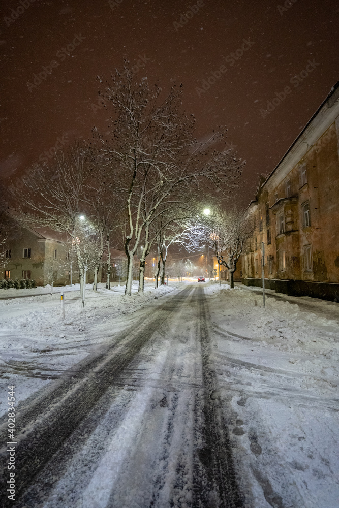 Cold winter night. Winter urban landscape. Snowfall.
