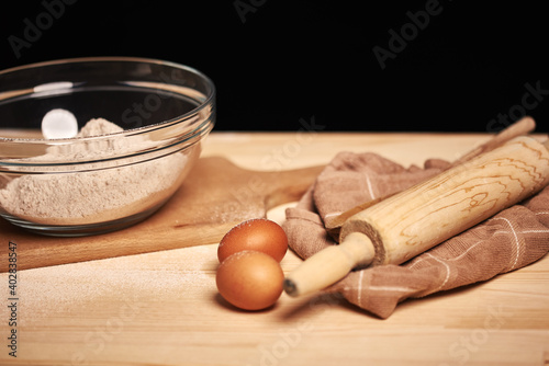 Ready ingredients for making a loaf of bread. Roller, eggs, and a chopping board visible. Natural homemade ingredients. 