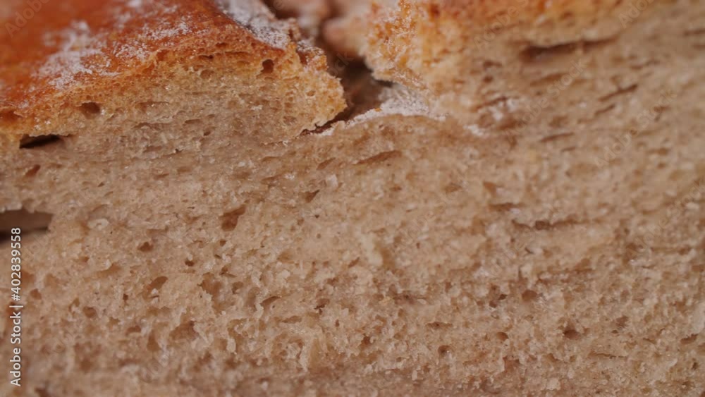 Close up of a fresh organic bread loaf being squeezed and the pores compressed. Mouthwatering homemade bread with crispy crust and soft dough. Tasty and healthy food texture. Macro, 4K. Close up of a fresh organic bread loaf being squeezed and the pores compressed. Mouthwatering homemade bread with crispy crust and soft dough. Tasty and healthy food texture. Macro, 4K.