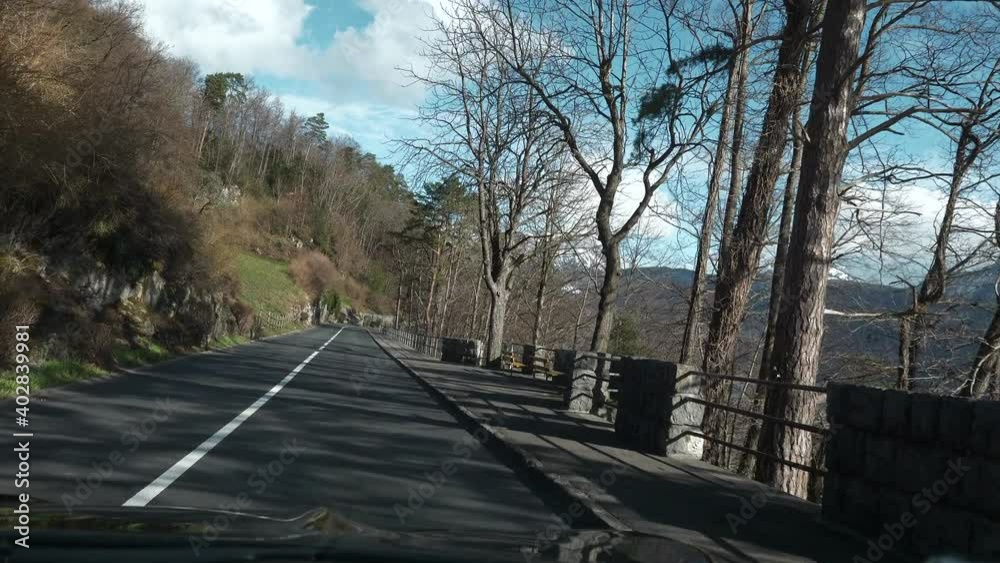 Traveling by Car along Mountain Road. POV Windshield Hood View On Picturesque Swiss Alps. Spring Switzerland Europe. Slow motion Traveling by Car along Mountain Road. POV Windshield Hood View On Picturesque Swiss Alps. Spring Switzerland Europe. Slow motion
