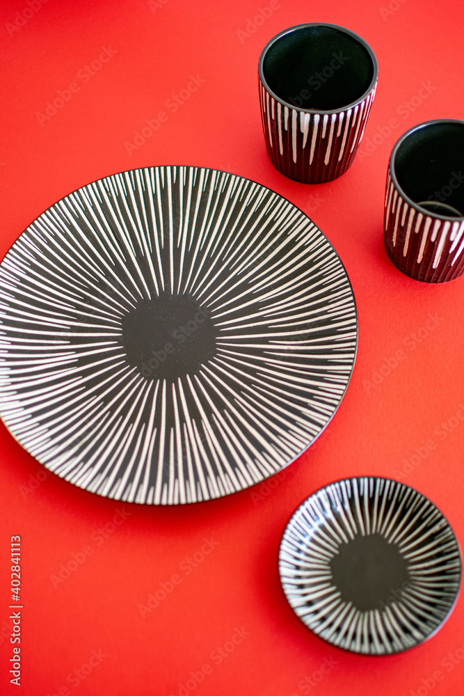 a grey ceramic plate set on a red background portrait 