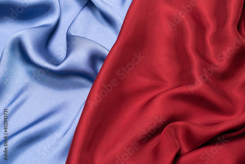 Red and blue silk or satin luxury fabric texture. Top view.