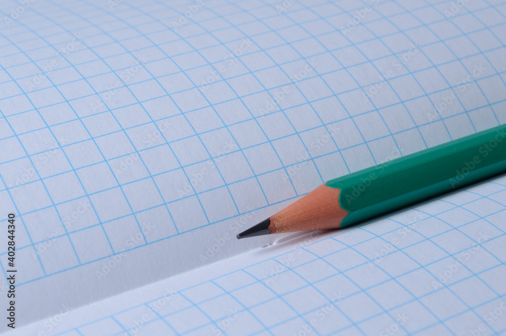 pencil lies on an open notebook. close-up. pencil lies on an open notebook. close-up.