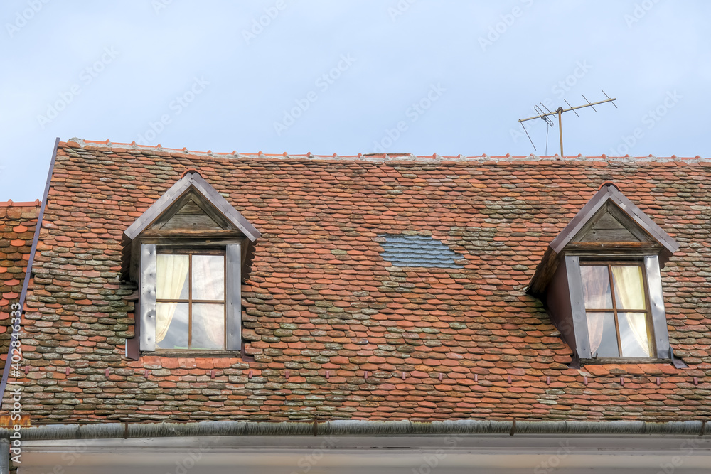 Romanian ceramic shingle roof with brick chimney and old television antenna