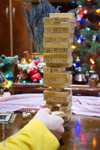 Family weekend leisure fun - building a tower from wooden blocks withour crashing photo