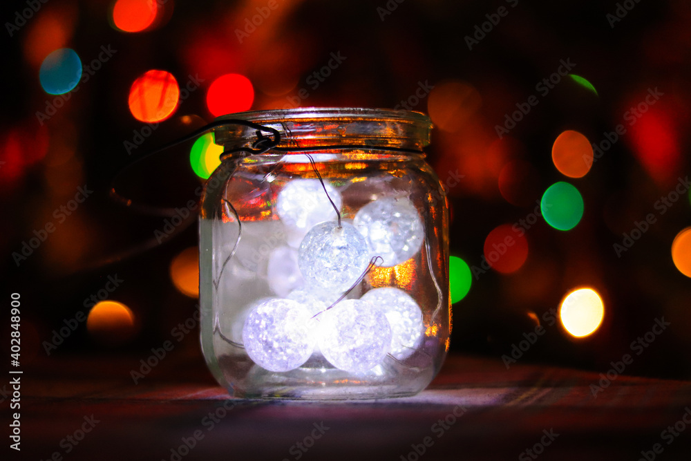 Transparent jar with led lights inside and Bokeh lights in background. Home decoration Transparent jar with led lights inside and Bokeh lights in background. Home decoration
