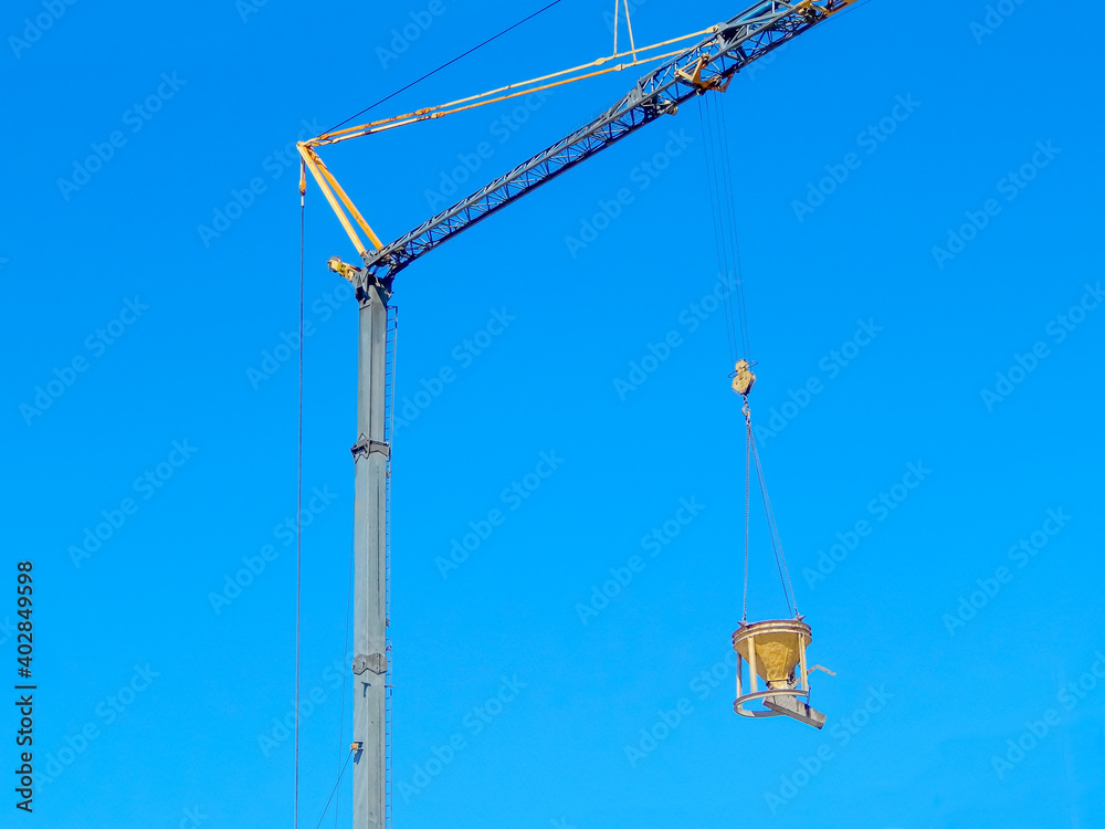 construction crane, stroyd building, against the blue sky
