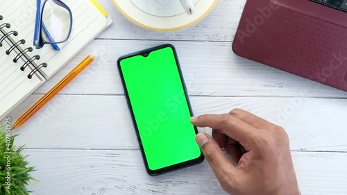 flat composition of man's hand browsing smart phone on office desk  photo