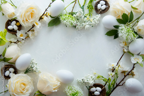 Easter floral frame with white eggs, green leaves and cherry flowers. Flat lay with copy space