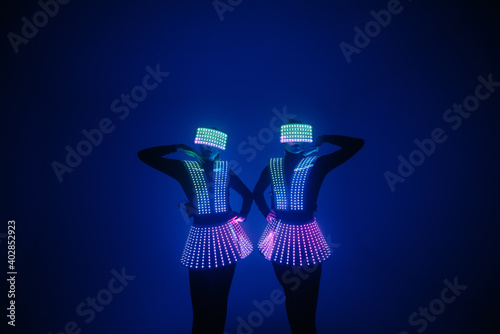 Foto Two sexy disco dancers move in UV costumes. Parties and dances.