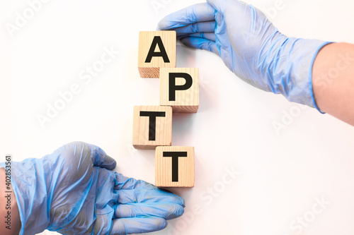 the doctor holds wooden cubes with text APTT. the medicine. medical concept photo