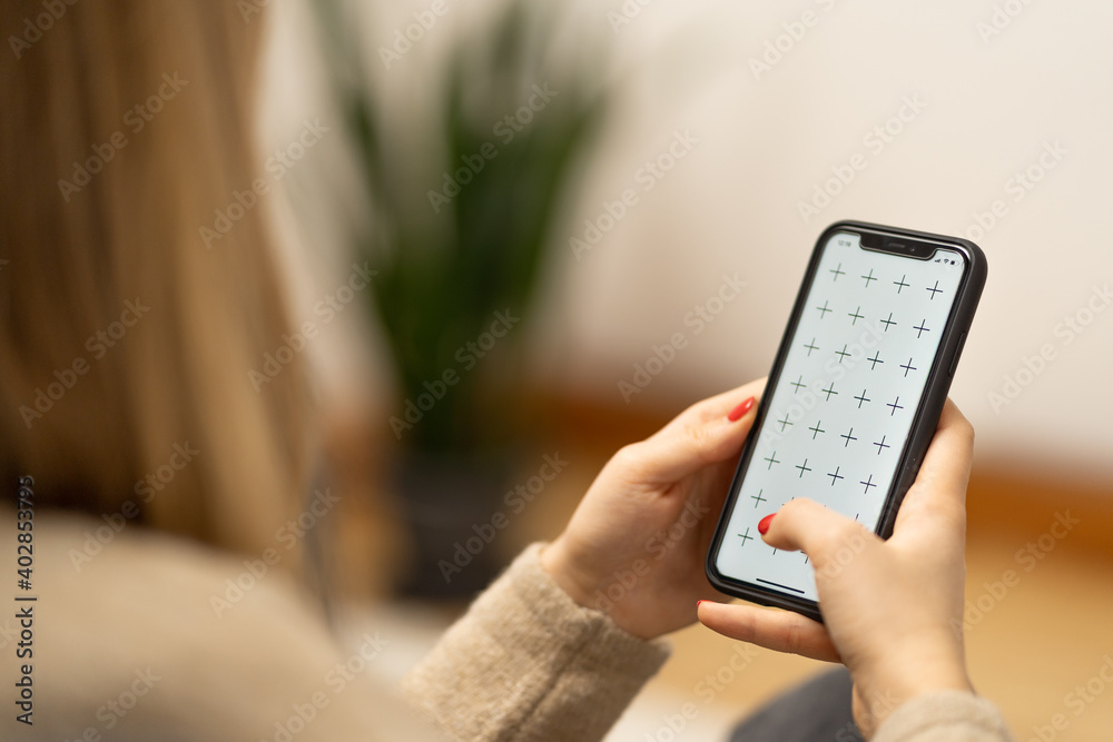 Girl holding smartphone in woman hands, browsing internet or application with blank screen mock-up for your design at home office with blurry background with free space for custom text Girl holding smartphone in woman hands, browsing internet or application with blank screen mock-up for your design at home office with blurry background with free space for custom text