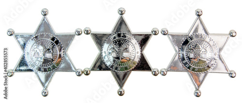 Three shiny toy plastic deputy sheriff badges photo