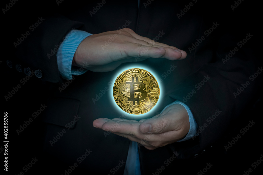 businessman holding bitcoin gold coin in dark background. Virtual cryptocurrency concept. digital currency coin.