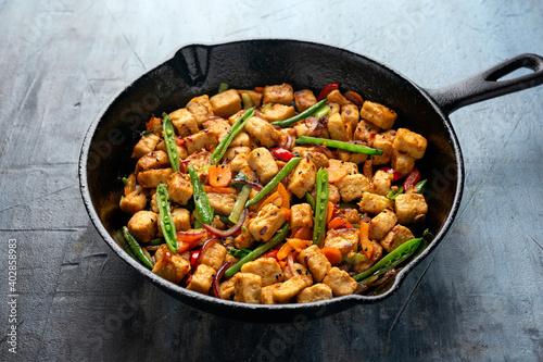 Vegetarian meat free mycoprotein pieces vegetable stir fry served in cast iron skillet frying pan