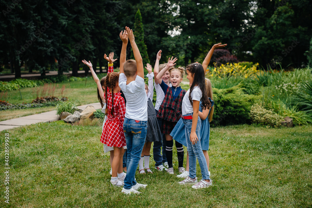 Fototapeta premium A group of children run around, have fun and play as a larger team in the summer in the Park. Happy childhood