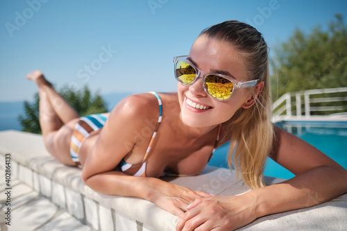 Holiday resort in Croatia. Woman next to swimming pool with sea view. Vacation relax. Sea with mountains at background