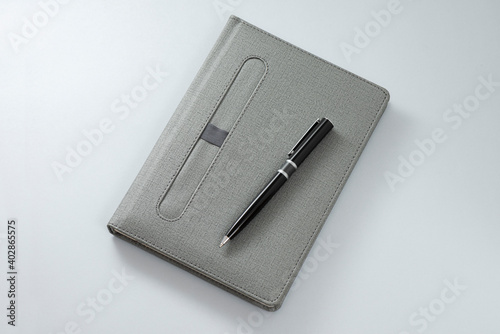 Gray notebook and black pencil an the gray background.