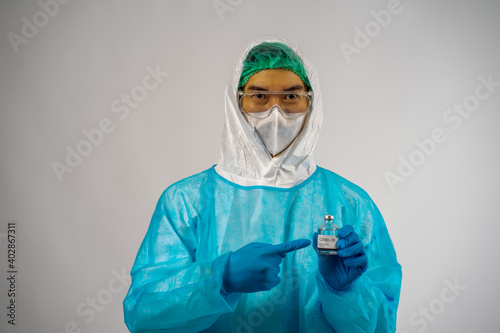 Asian medical scientist man in PPE suit protection with virus pandemic vaccine in hands on white background copy space. healthcare and medicine concept. 