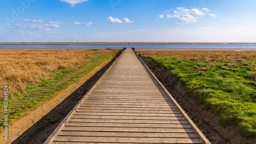 A wooden path leading to the shore of the River Ribble, seen in Lytham, Lancashire, England, UK