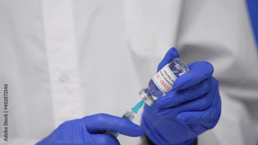 Male Doctor holds syringe and bottle of Coronavirus COVID-19 vaccine, Concept of corona virus treatment and Healthcare concept. Blue Screen, Chroma Key. Close up. Slow motion. Male Doctor holds syringe and bottle of Coronavirus COVID-19 vaccine, Concept of corona virus treatment and Healthcare concept. Blue Screen, Chroma Key. Close up. Slow motion.