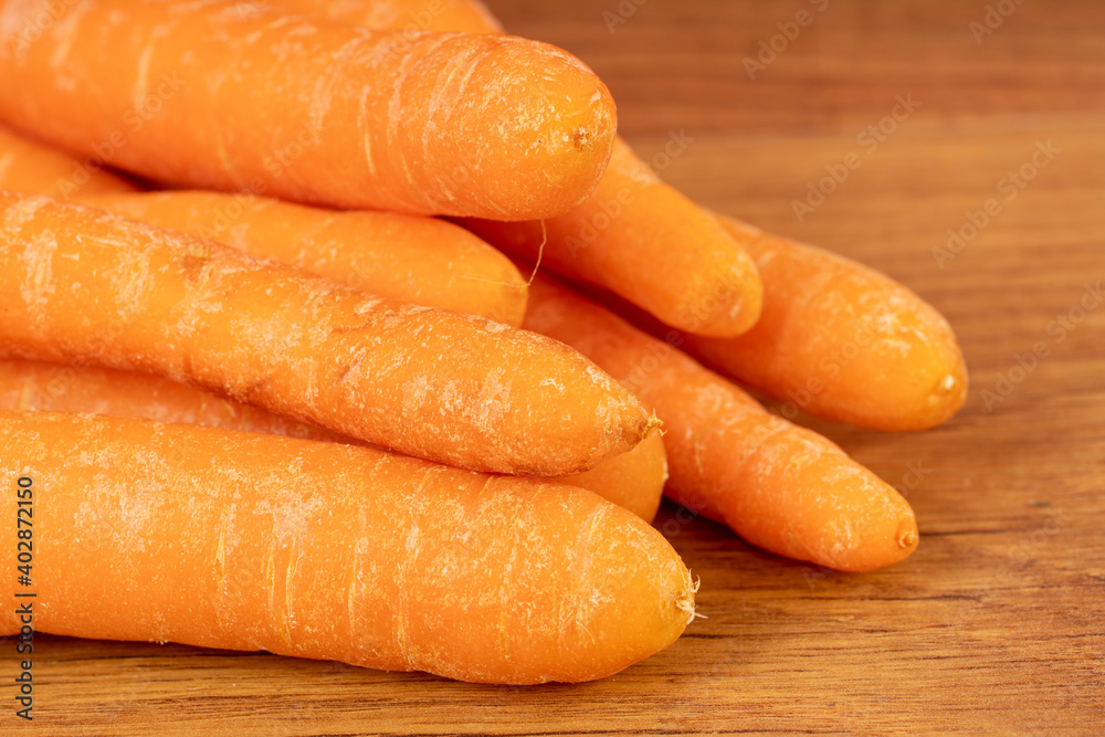 Carrots on a brown wooden kitchen table Carrots on a brown wooden kitchen table