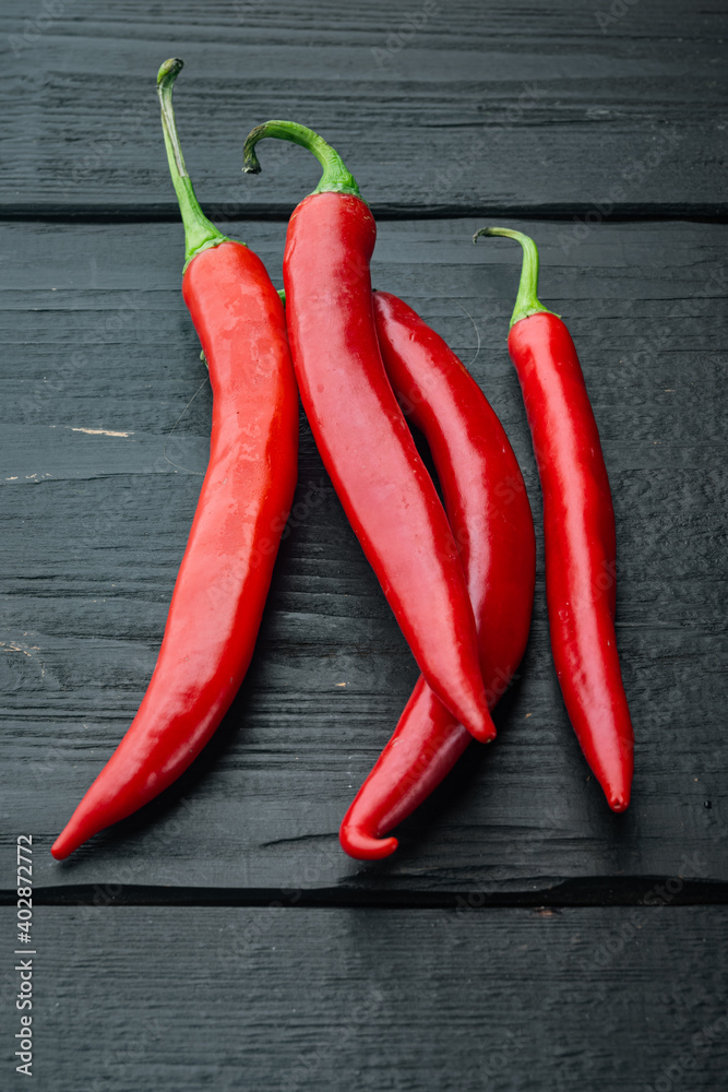 Whole red chili peppers, on black wooden background