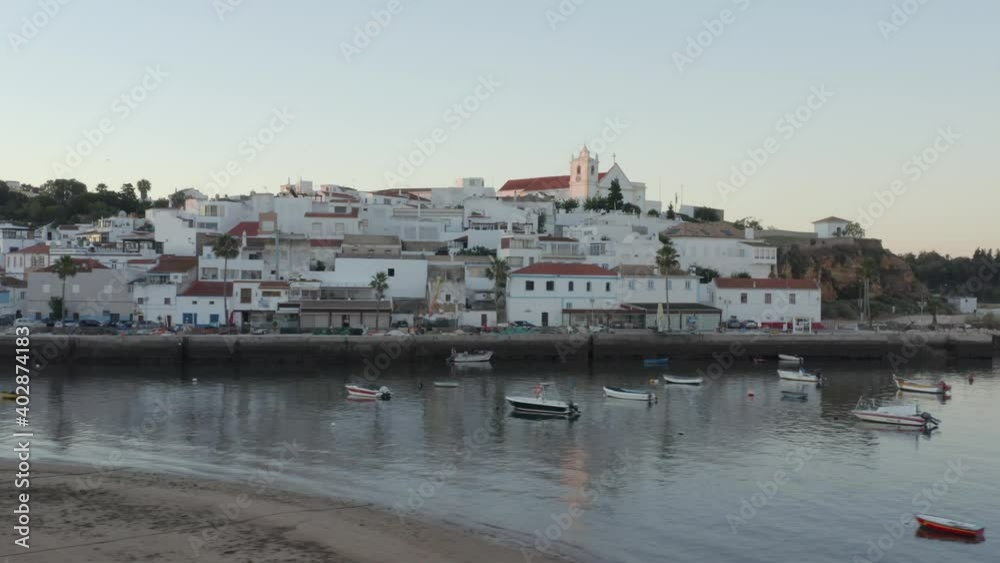 Ferragudo looking splendid as birds fly by overhead, Portugal. Drone