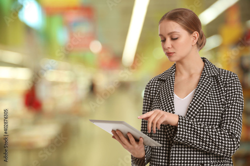 Inspector with tablet in shopping mall, space for text. Quality control